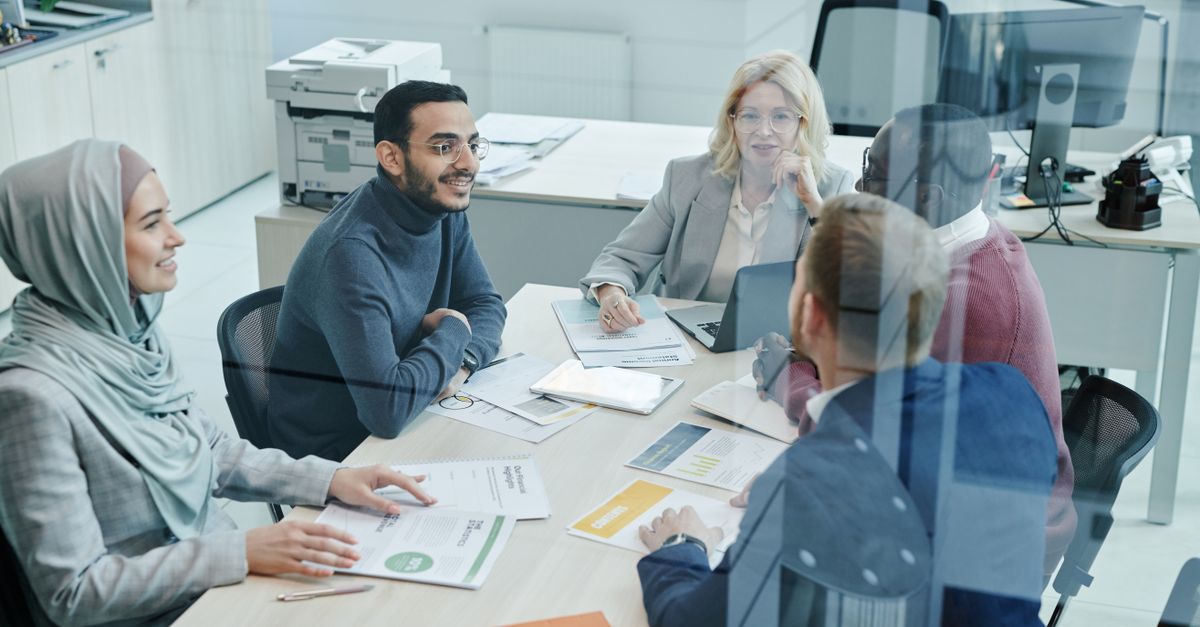 A diverse team of HR professionals discussing recruitment strategies around a conference table